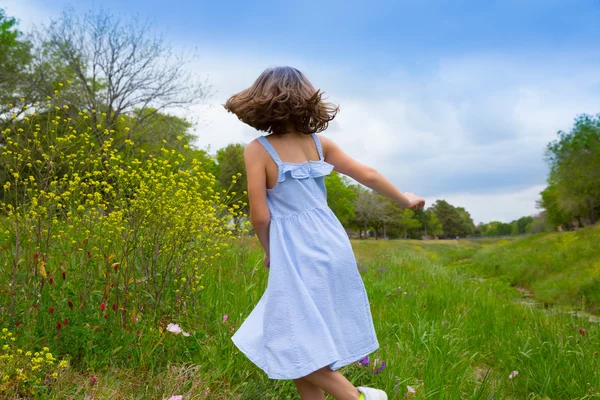 Niña feliz saltando sobre flores de amapola de primavera — Foto de Stock