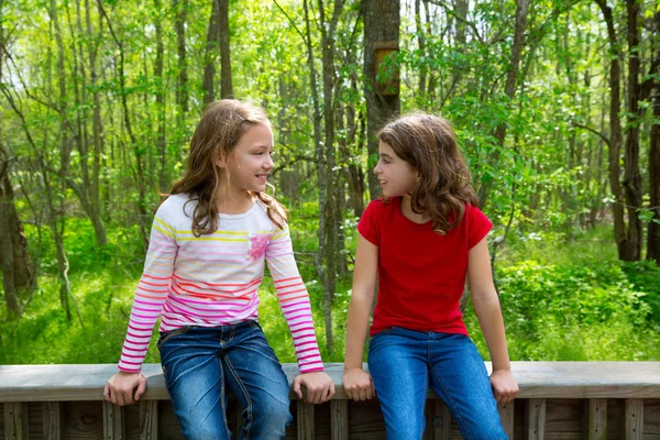 Orman park orman üzerinde konuşurken çocuk arkadaş kızlar — Stok fotoğraf