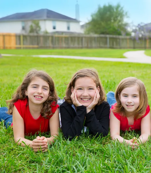 Crianças meninas grupo deitado na grama gramado sorrindo feliz — Fotografia de Stock