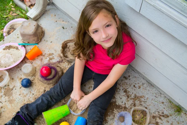 Feliz niña jugando con barro con las manos sucias sonriendo — Foto de Stock