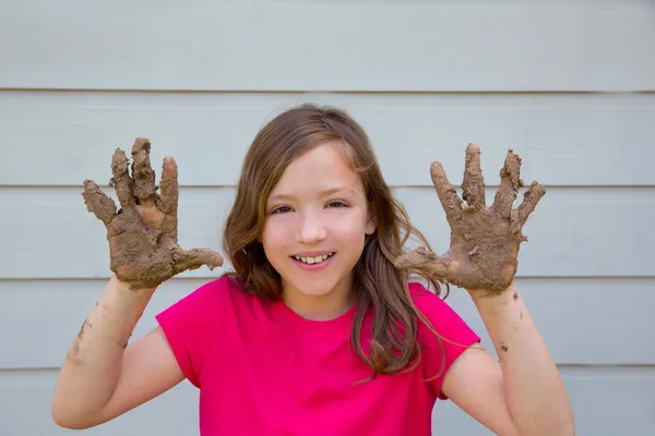 Happy kid girl playing with mud with dirty hands smiling — Stock Photo, Image