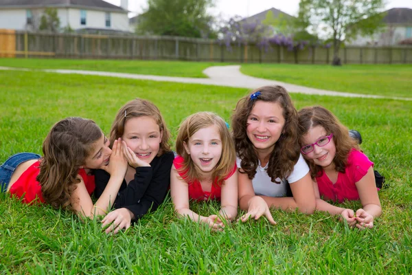 Kindermädchengruppe liegt auf Rasen und lächelt glücklich — Stockfoto