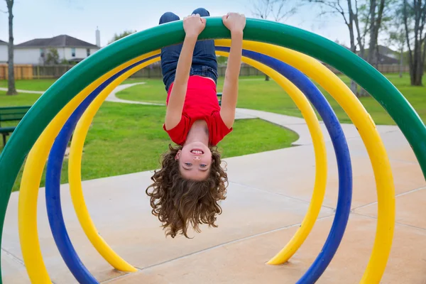 Crianças criança menina de cabeça para baixo em um anel de parque — Fotografia de Stock