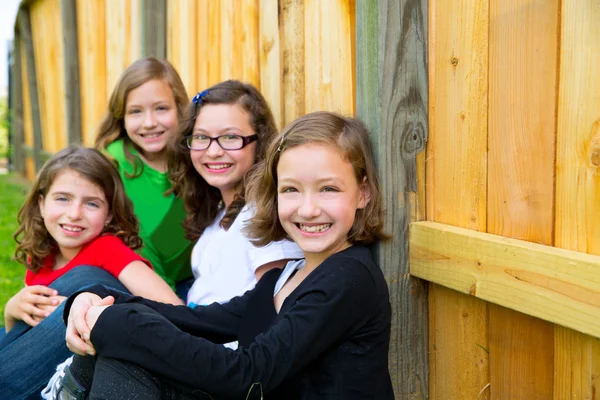 Grills Gruppe in einer Reihe lächelnd in einem Holzzaun — Stockfoto