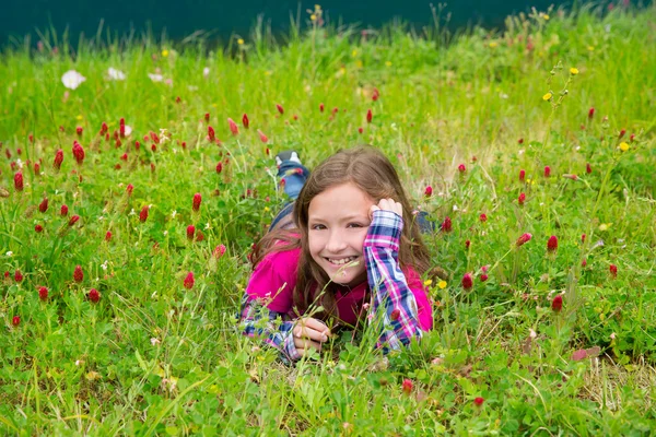 Happy relaxed kid girl on a spring flowers meadow — Stock Photo, Image