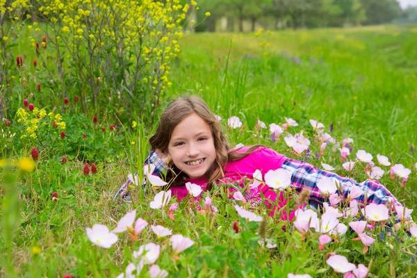 春の花の牧草地に幸せなリラックスした子供の女の子 — ストック写真