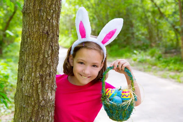 Påsk tjej med ägg korgen och roliga bunny ansikte — Stockfoto