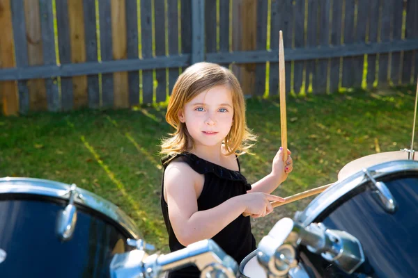 Trummisen blond liten flicka spelar trummor i tha bakgård — Stockfoto