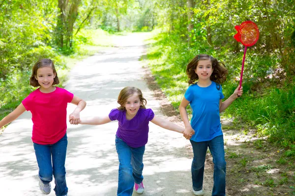 Amigos e irmãs meninas correndo na trilha da floresta feliz — Fotografia de Stock