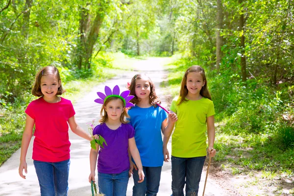 Vrienden en zus meisjes lopen buiten in het bos bijhouden — Stockfoto