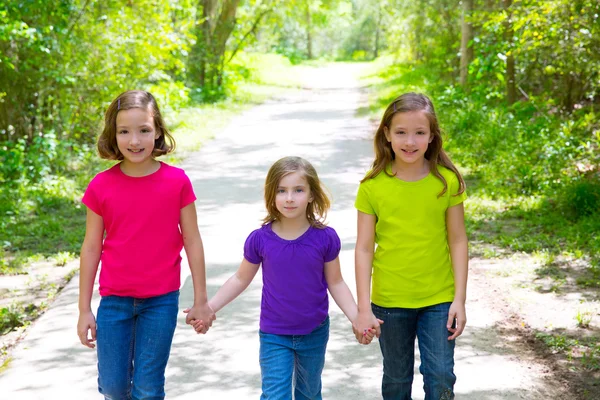 Friends and sister girls walking outdoor in forest track — Stock Photo, Image