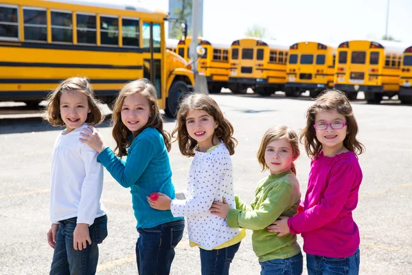 School girls friends in a row walking from school bus — Stock Photo, Image