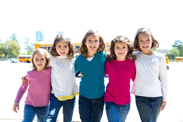 School girls friends in a row walking from school bus — Stock Photo, Image