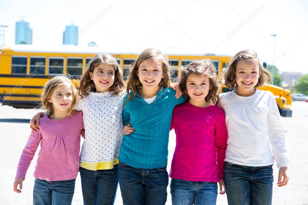 school girls friends in a row walking from school bus