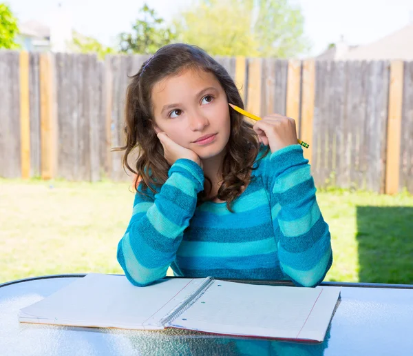 Americano latino giovanissima ragazza doing homework su backyard — Foto Stock