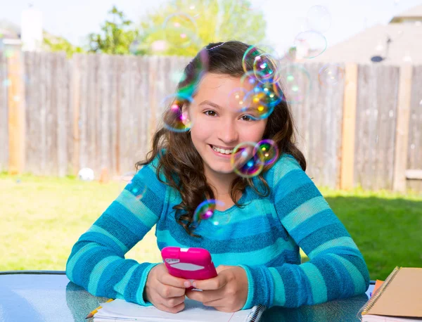 Menina adolescente com smartphone fazendo lição de casa — Fotografia de Stock