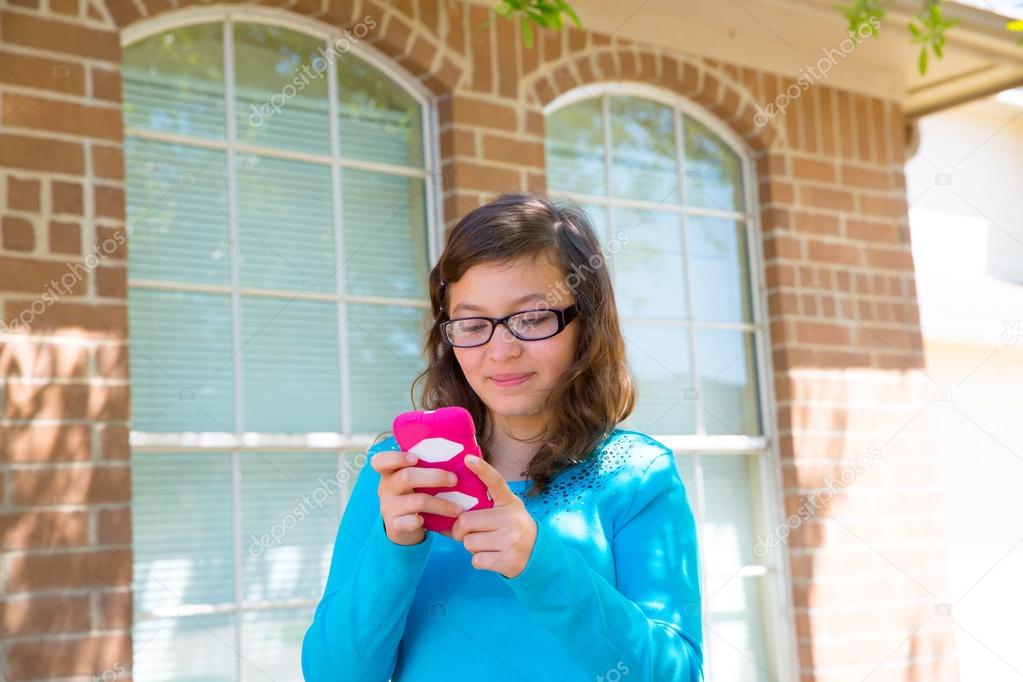 Teenager girl with glasses playing with smartphone