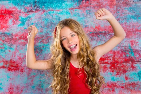 Blond happy children girl in red happy arms up — Stock Photo, Image