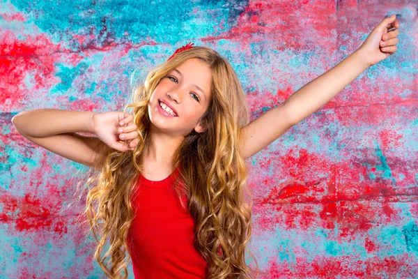 Loira menina criança feliz em vermelho feliz com os braços para cima — Fotografia de Stock