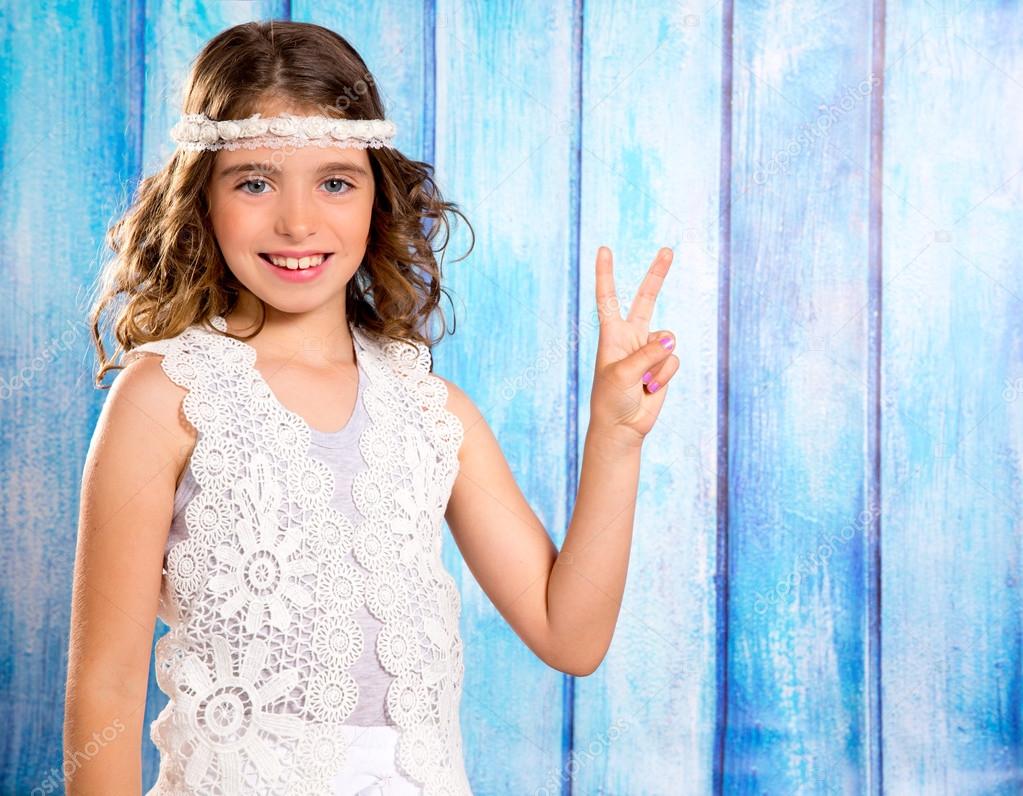 Happy hippie children girl smiling with peace hand sign