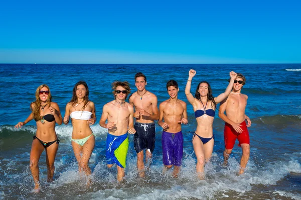 Adolescentes grupo corriendo feliz chapoteo en la playa — Foto de Stock