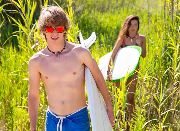 Surfista chico y chica caminando en la selva verde —  Fotos de Stock