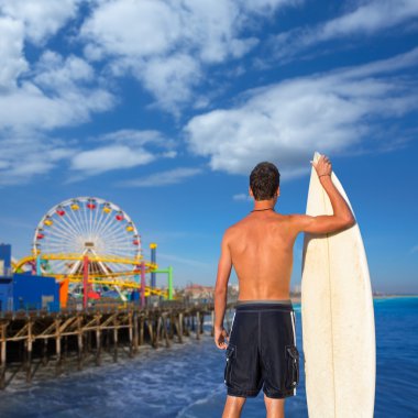 Çocuk sörfçü geri görüntülemek surfboard holding kumsalda