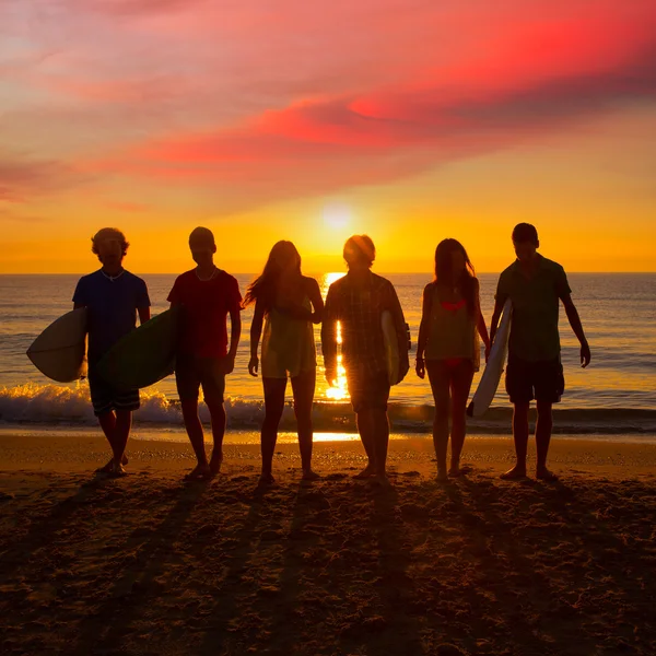 Surfers jongens en meisjes groep lopen op strand — Stockfoto