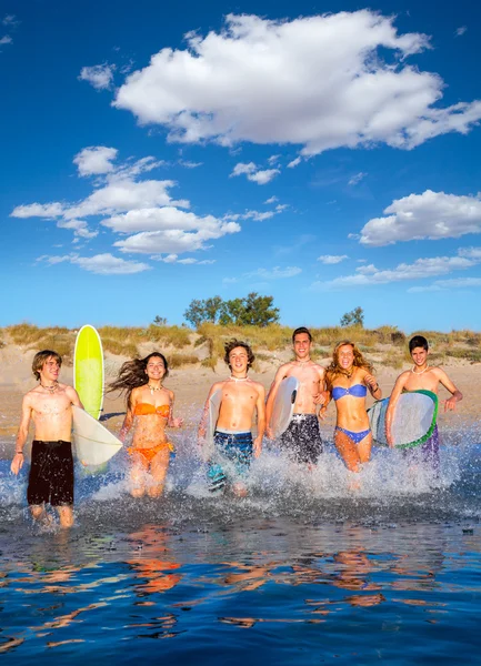 Teen surfisti gruppo corsa spiaggia schizzi — Foto Stock