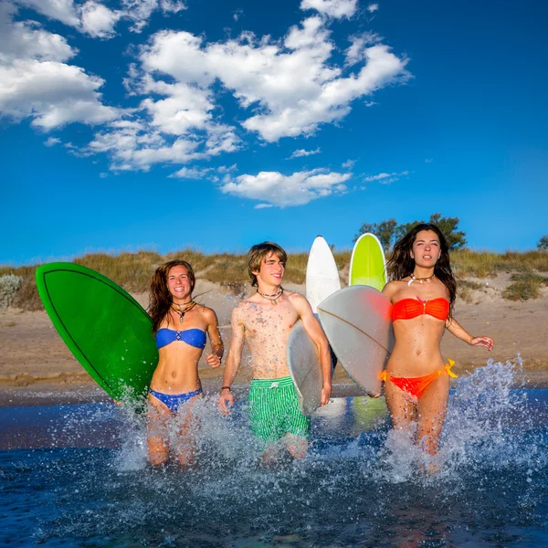 Adolescente surfistas grupo correndo praia espirrando — Fotografia de Stock