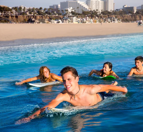 Teenager surfer boys and girls swimming ove surfboard — Stock Photo, Image