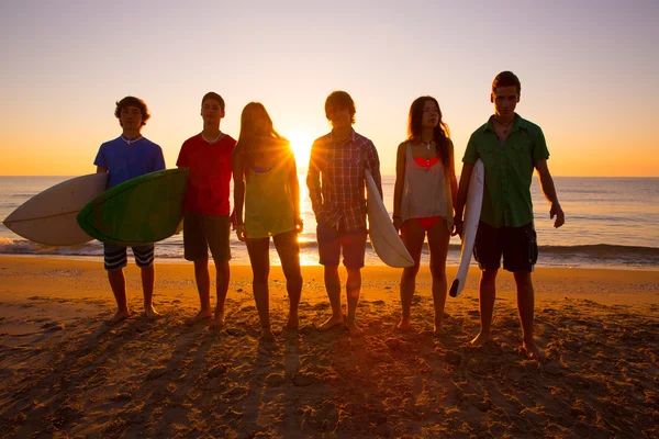 Surfistas grupo de niños y niñas caminando en la playa —  Fotos de Stock