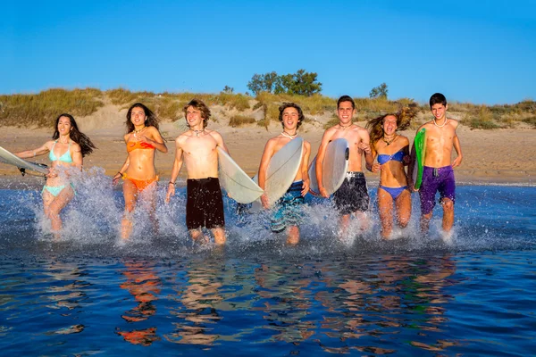 Adolescentes surfistas grupo corriendo playa chapoteo —  Fotos de Stock