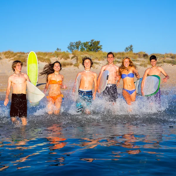 Adolescentes surfistas grupo corriendo playa chapoteo —  Fotos de Stock