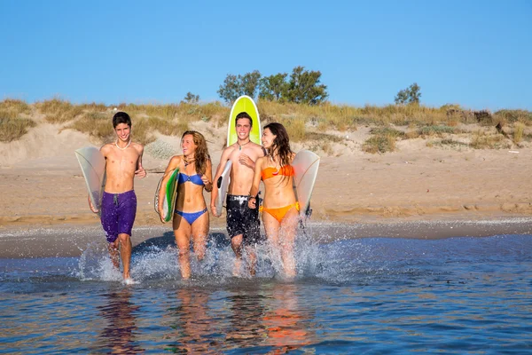 Teenager surfers group running beach splashing — Stock Photo, Image