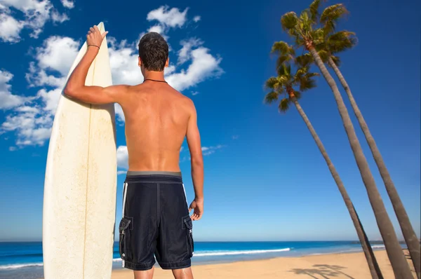 Niño surfista vista trasera celebración de tabla de surf en la playa —  Fotos de Stock