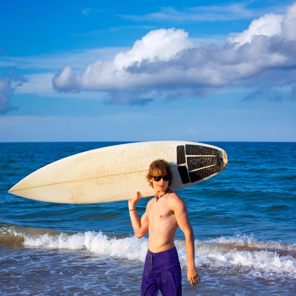 Мальчик-сёрфер счастливо катается на серфинге на пляже — стоковое фото