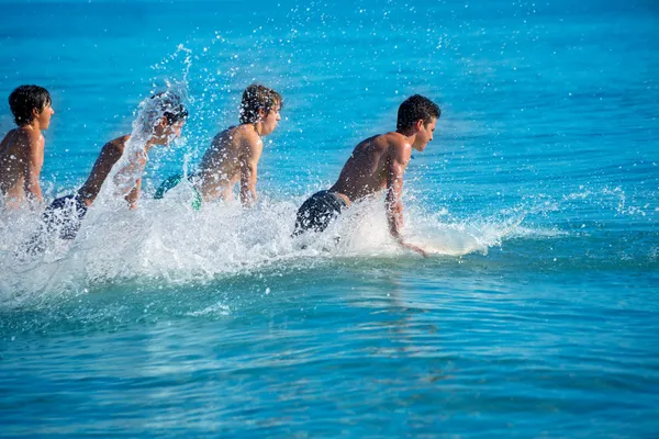 Boys surfers surfing running jumping on surfboards — Stock Photo, Image