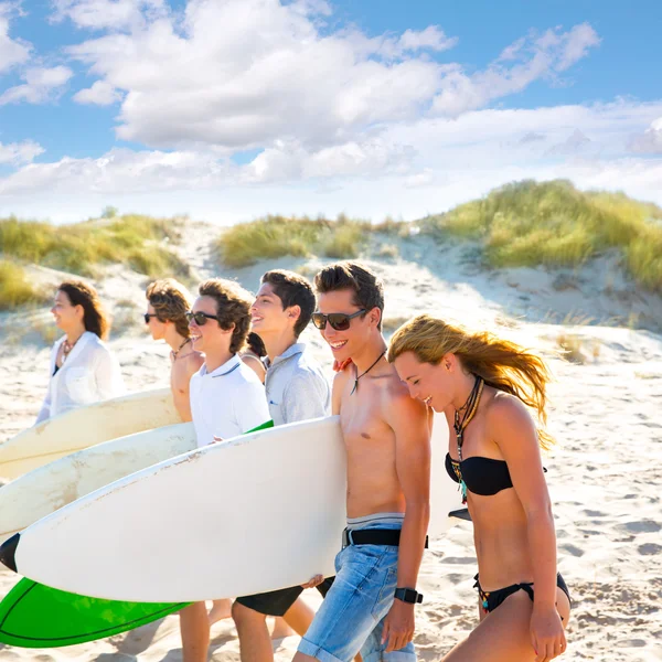 Surfer tonåring pojkar och flickor grupp promenader på stranden — Stockfoto