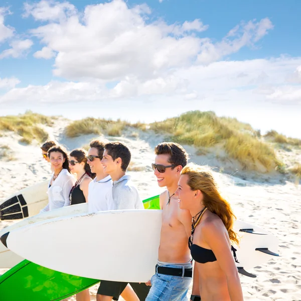 Surfer tonåring pojkar och flickor grupp promenader på stranden — Stockfoto