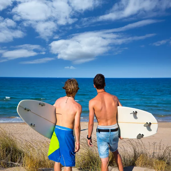 Niños adolescentes surfistas vista trasera mirando a la playa —  Fotos de Stock