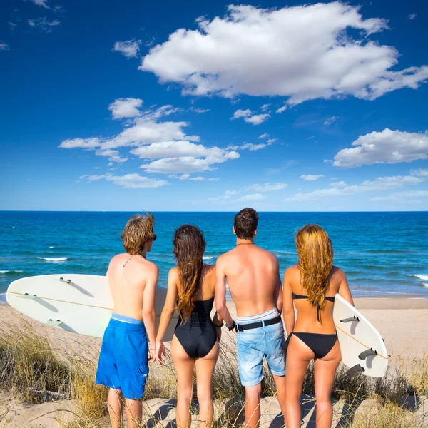 Αγόρια και κορίτσια εφήβων surfers πίσω θέα ψάχνει παραλία — Φωτογραφία Αρχείου