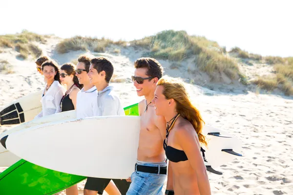 Surfer tiener jongens en meisjes groep lopen op strand — Stockfoto