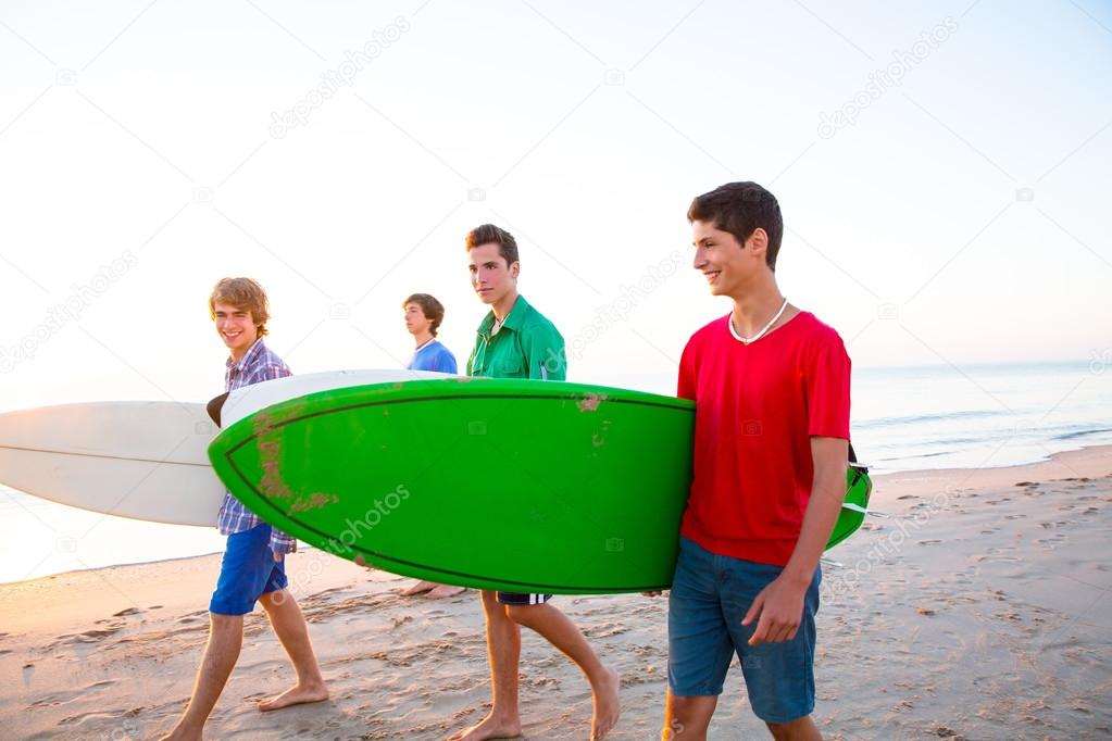 Surfer teen boys walking at beach shore