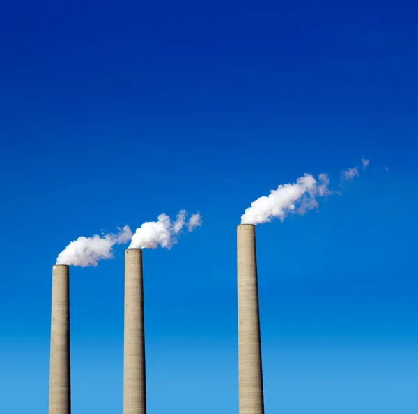 Chimenea humo blanco tres en una fila en un cielo azul —  Fotos de Stock