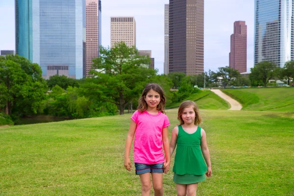 Duas meninas amigas andando de mãos dadas no horizonte urbano — Fotografia de Stock