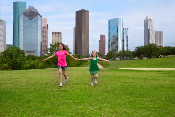 Dos hermanas amigas corriendo cogidas de la mano en el horizonte urbano —  Fotos de Stock