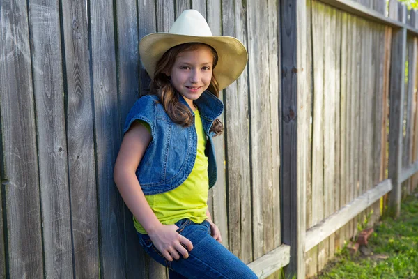 Children girl as kid cowgirl posing on wooden fence — Stock Photo, Image