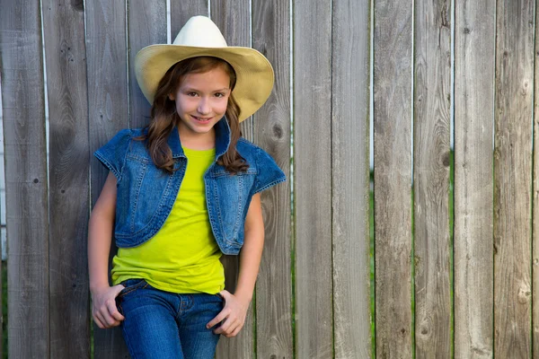 Crianças menina como cowgirl criança posando na cerca de madeira — Fotografia de Stock