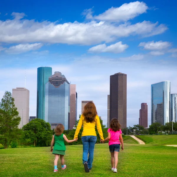 Mother and daughters walking holding hands on city skyline — Stock Photo, Image